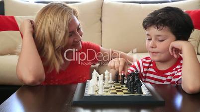 Mother teaches son how to play chess