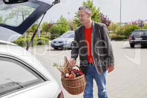 Man lifts filled basket in the car