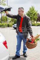 Man lifts filled basket in the car