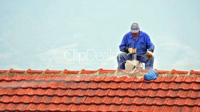 Chimney sweep - Stock Image Chimney sweep working on a roof sitting on edge.