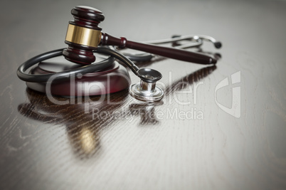 Gavel and Stethoscope on Reflective Table