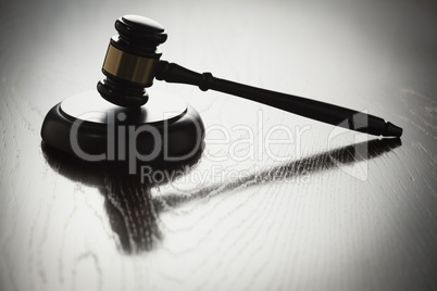 Dramatic Gavel Silhouette on Reflective Wood