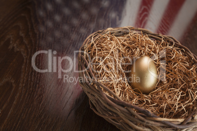 Golden Egg in Nest with American Flag Reflection on Table