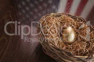 Golden Egg in Nest with American Flag Reflection on Table