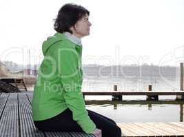 Woman sitting by the lake