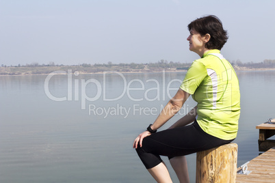 Woman sitting by the lake