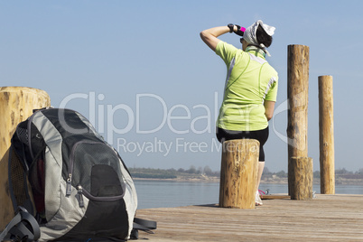 Woman sitting on the boat dock and resting from the hike from