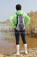 Woman stands at the reed-covered lake