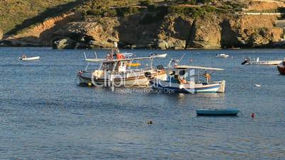 The traditional Greek boats for fishing near beach at sunset, Crete, Greece