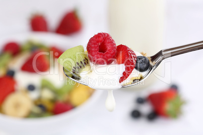 Früchte Joghurt mit Tropfen auf Löffel zum Frühstück