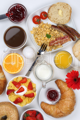 Frühstückstisch mit Müsli, Kaffee, Früchten und Brötchen vo