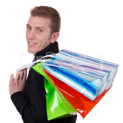 Lachender junger Mann beim Einkaufen mit Taschen