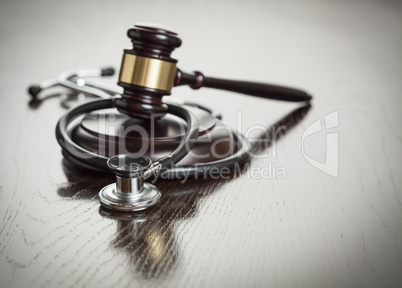 Gavel and Stethoscope on Reflective Table