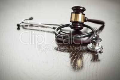 Gavel and Stethoscope on Reflective Table