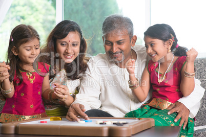 happy indian family playing carrom game