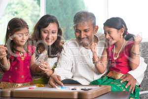happy indian family playing carrom game