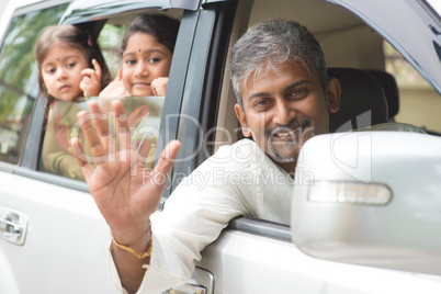 indian family waving hands in car