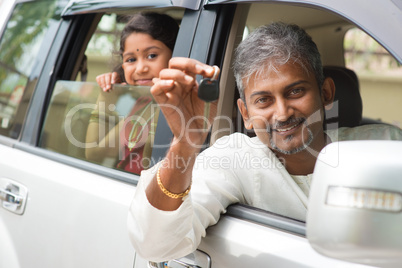 indian man showing his new car key.