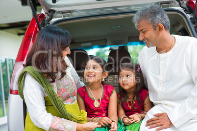 indian family in car infront new house.