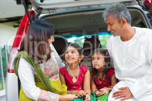 indian family in car infront new house.