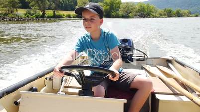 junge steuert Motorboot
