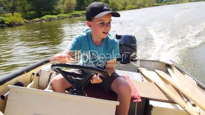 Junge steuert ein Motorboot