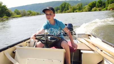 Junge steuert ein Motorboot