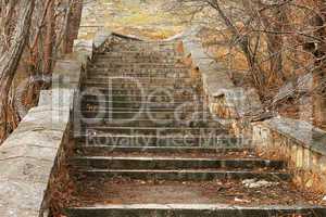 Old stone stairs leading up in autumn park
