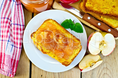 Bread with apple jam in plate on board