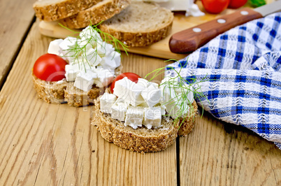 Bread with feta and tomatoes on board with napkin
