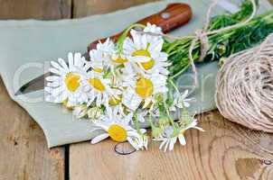 Chamomile with a knife and napkin on board