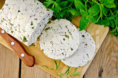 Cheese homemade with herbs and knife on board