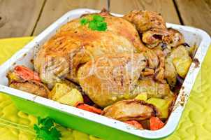 Chicken baked with vegetables in tray on board