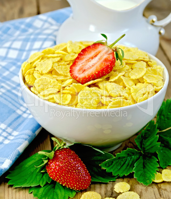 Cornflakes in bowl with strawberries on board