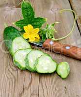 Cucumber sliced with flower and knife on board