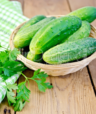 Cucumbers in wicker basket on board