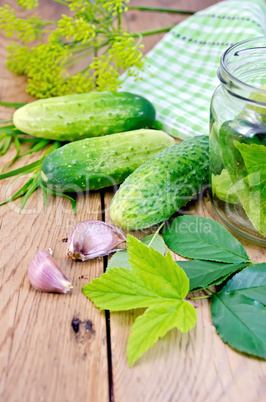 Cucumbers with jar and garlic on board