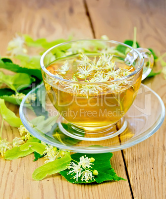 Herbal tea from linden flowers in glass cup on board