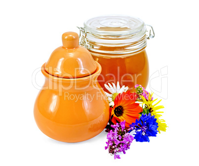 Honey in a jug and jar with flowers