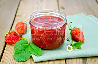 Jam of strawberry with berries and leaf on board