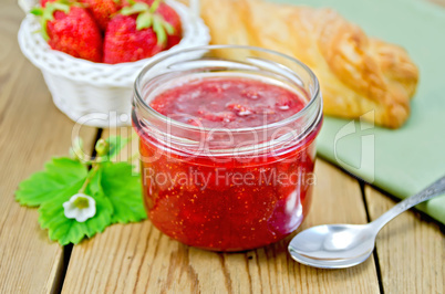 Jam of strawberry with bun and basket on board