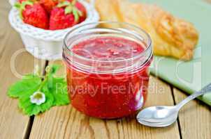 Jam of strawberry with bun and basket on board