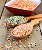 Lentils red and green in spoon with bowl on board