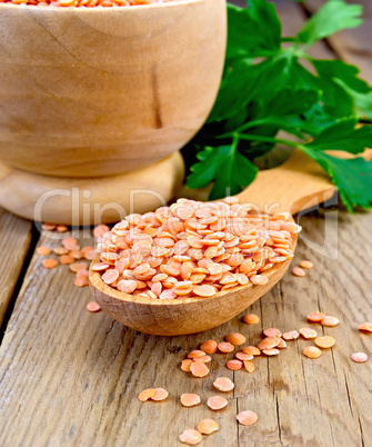 Lentils red in wooden utensil on board