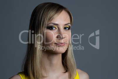 Portrait of a girl with makeup on gray background