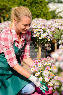 garden center woman looking down potted flowers
