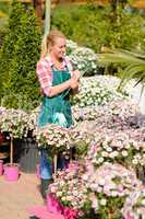 garden center woman write notes potted flowers