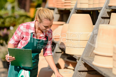 garden center woman looking down clay pots