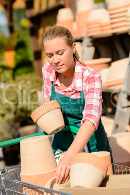 garden center woman putting clay pots cart