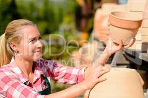 garden center woman putting clay pots shelf
